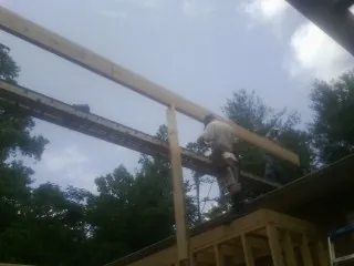 Carpenter setting a ridge beam over a new addition frame — Ice Dam Removal by Roofing Brothers in Richville