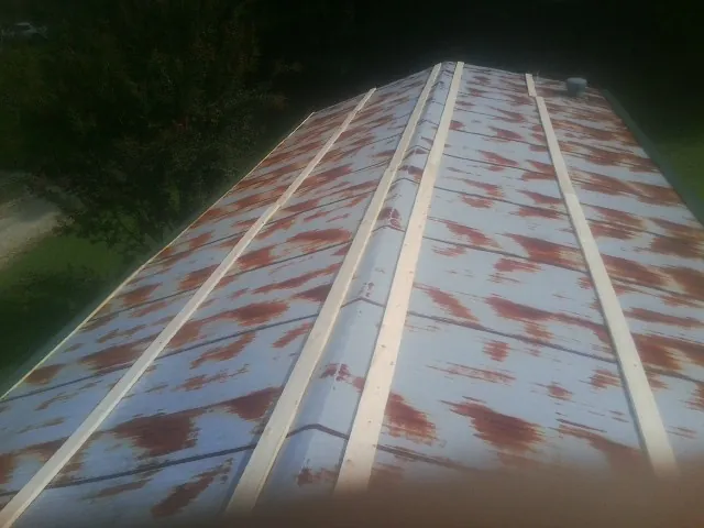 Rusted metal roof panels with new wood purlins before replacement — Storm Damage Roof Repair in Richville by Roofing Brothers