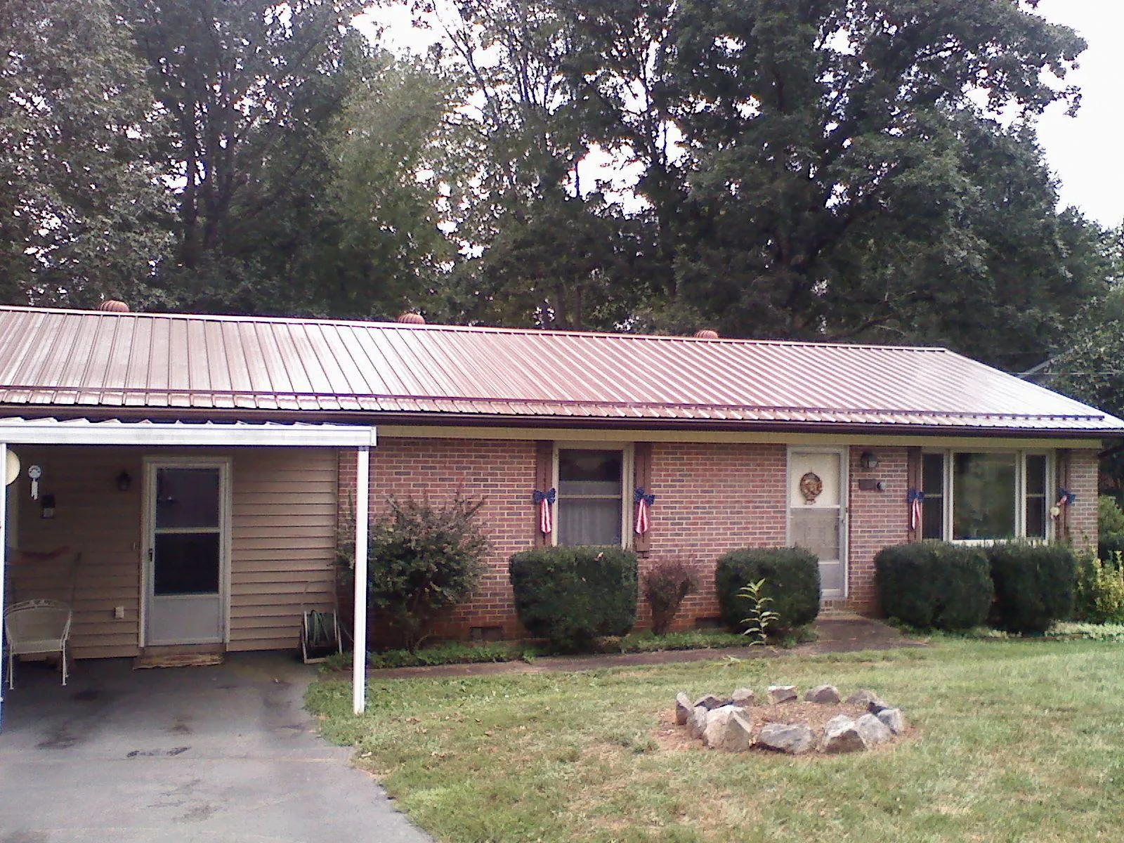 Bronze metal roof and carport on a brick ranch home — Roof Repair work by our crew in Richville